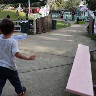 Child Running Through a Community Playground Path