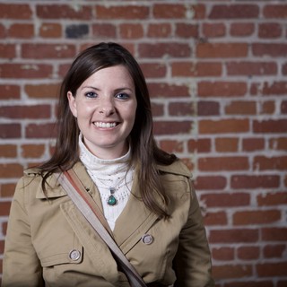 Smiling Woman Poses Against Rustic Brick Wall