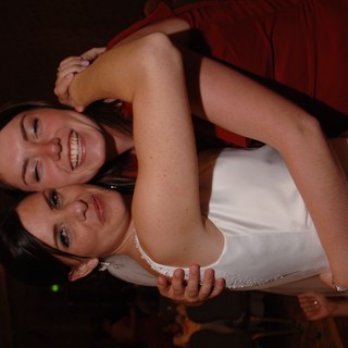 Bride and Bridesmaid Share Joyful Wedding Embrace