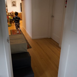Young Child Running Through Modern Home Hallway