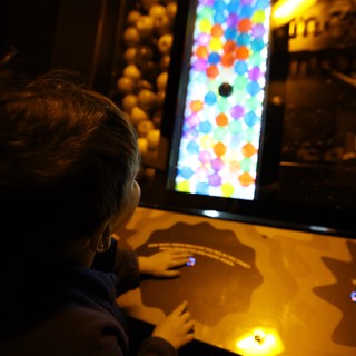 Child Playing Interactive Bubble Game at Science Center