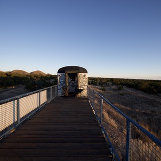 Wooden Boardwalk Leading to Desert Observation Structure at Dusk