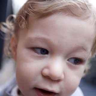 Curious Toddler with Blonde Curls Close-Up Portrait