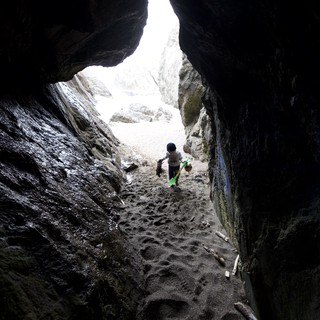 Young Explorer Ventures Into a Rocky Sea Cave