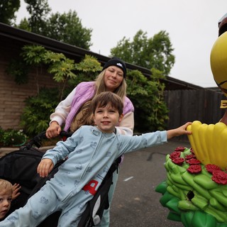 Boy Reaches for Hot Air Balloon Sculpture at Festival