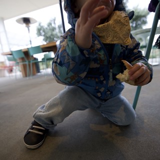 Toddler in Blue Patterned Jacket Reaches Upward