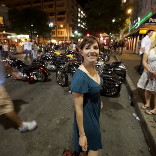 Woman Smiling on Lively Austin Street at Night