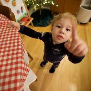 Toddler Pointing at Camera in Cozy Home Setting