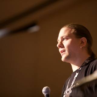 Rocking the Mic Caption: A long-haired man captivates the crowd with his electrifying speech at the 2009 Defcon 17 conference.