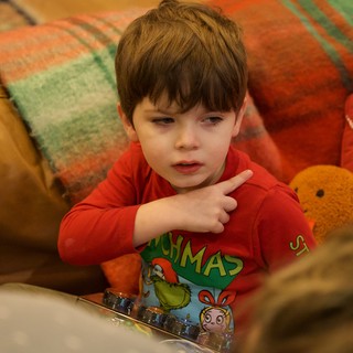 Young Boy in Christmas Pajamas Engaged with Device