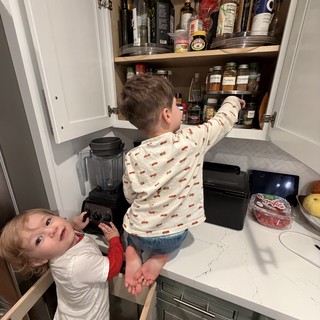 Young Brothers Exploring Kitchen Cabinet Together