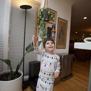 Joyful Child Playing with Wooden Sword in Cozy Home