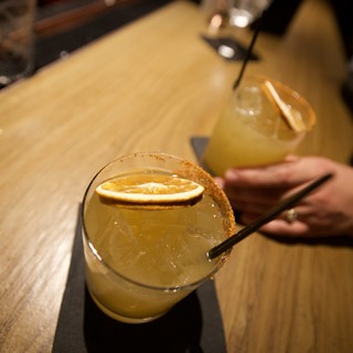 Craft Cocktails with Citrus Garnish on Wooden Bar