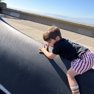 Young Boy Peering Over Urban Skateboard Ramp Edge