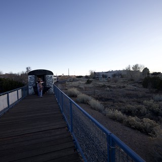 Twilight Walk on Blue Pedestrian Bridge in Desert Landscape