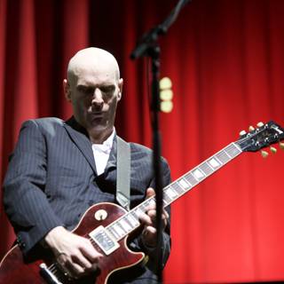 Bald Man Rocks Electric Guitar in Coachella Suit