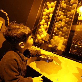 Child Exploring Interactive Ball Physics Exhibit at Science Museum