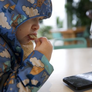 Young Child Enjoying Meal at Restaurant Table
