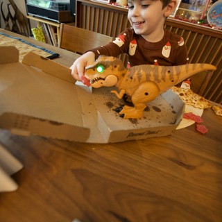 Child Playing with Dinosaur Toy at Christmas Pizza Dinner