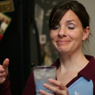 Woman with Drink Gives Thumbs Up at Party