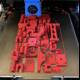 Red plastic car model being printed by 3D printer