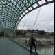 Man stands in awe of stunning glass architecture on Tbilisi bridge