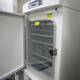 The Big Chill Caption: A large white freezer with the door open, revealing shelves stocked with frozen goods, protected by a gloved hand.