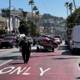 Man Transporting Car on Trailer Through Urban Streets