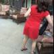 Woman in Red Dress Relaxing on Patio Couch