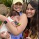 Two Women Bask in the Joy of Holding a Newborn Baby Outdoors