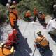 Orange-clad Rescuers Scaling Rocky Terrain