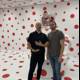 Two Men Standing in Front of a Bold Polka Dot Wall
