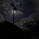 Silhouette of a Lamppost Against Cloudy Night Sky
