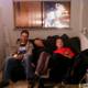 Three People Relaxing on a Cozy Living Room Couch
